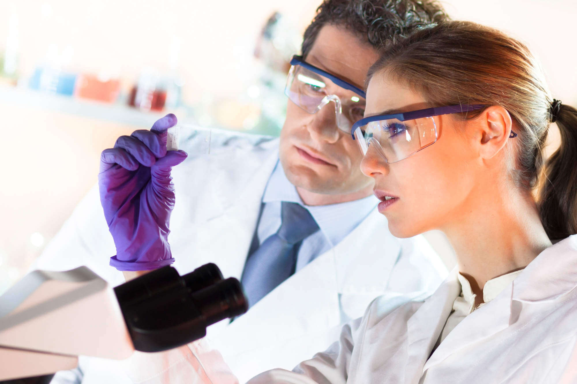 Scientific colleagues in front of a microscope